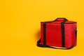 Modern red thermo bag on yellow background. Space for text Royalty Free Stock Photo