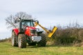 Modern red tractor hedge cutting