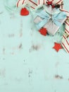 Modern red and white Christmas decorations on aqua blue wood background, with silver gift - vertical. Royalty Free Stock Photo