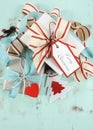 Modern red and white Christmas decorations on aqua blue wood background, with white gift closeup - vertical. Royalty Free Stock Photo