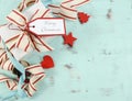 Modern red and white Christmas decorations on aqua blue wood background, with white gift and copy space. Royalty Free Stock Photo