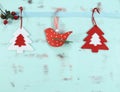 Modern red and white Christmas hanging bird and tree decorations on aqua blue wood background. Royalty Free Stock Photo