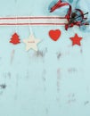Modern red and white hanging Christmas decorations on aqua blue wood background. Vertical. Royalty Free Stock Photo