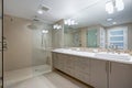 Modern refreshing bathroom with a beige dual washstand.