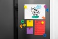 Modern refrigerator with child`s drawing, notes and magnets