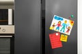 Refrigerator with child`s drawing, notes and magnets in kitchen