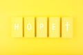 Modern religious minimal concept of hope with christian cross on bright yellow background Royalty Free Stock Photo