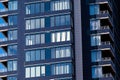 A modern residential building in dark blue with large glass windows against the sky. Skyscraper close up. Business building Royalty Free Stock Photo