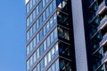 A modern residential building in dark blue with large glass windows against the sky. Skyscraper close up. Business building Royalty Free Stock Photo