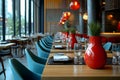 Modern restaurant interior with long table setting, red vase decor and glassware Royalty Free Stock Photo