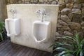 Modern restroom interior photo with urinal row. Royalty Free Stock Photo