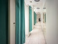 Modern retail changing room hallway featuring teal privacy curtains, a reflective mirrored wall, and ceiling ventilation, ready Royalty Free Stock Photo