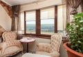 Modern retro design attic loft. Small vintage table with armchairs under the window for relax