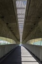 Modern road junction and Pedestrianized road is beneath motorway.