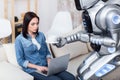 Modern robot giving cup of coffee to cheerless girl