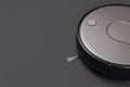Modern robot vacuum cleaner on black background copy space. New technologies, quick house cleaning, automatic robot assistant. Royalty Free Stock Photo