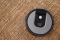 Modern robotic vacuum cleaner on brown rug. Space for text