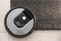 Modern robotic vacuum cleaner on dark carpet. Space for text