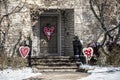 Modern rock house entrance and porch in snow with valentimes decorations and landscaping - selective color