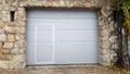 Modern roll up garage doors inside traditional stone wall frame