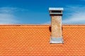 Modern roof with chimney. Orange ceramic tile, shingle
