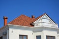 Luxury roofing constraction with natural clay roof tiles, house attic balcony and metal shutters, blinds.