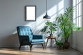 modern room interior with blank white picture frame, blue armchair and house plant against a gray wall with sunlight from large Royalty Free Stock Photo