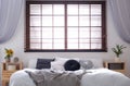 Modern room interior with double bed and window blinds