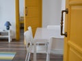 Modern room with yellow doors and white walls and furniture. Living room view through the ajar door Royalty Free Stock Photo