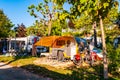 Modern round yellow gray camper with shaded terrace in the morning in camping La Ca located on the southern shore of Garda lake