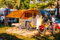 Modern round yellow gray camper with shaded terrace in the morning in camping La Ca located on the southern shore of Garda lake