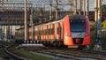 Modern intercity high speed train under the bridge on railroad at sunset Royalty Free Stock Photo