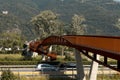 Modern rusted pedestrian and bicycle bridge with flowing Ticino river below. Beautiful panorama, Royalty Free Stock Photo