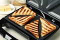 Modern sandwich maker with bread slices on white table, closeup Royalty Free Stock Photo