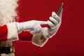 Modern Santa Claus using tablet pc over red