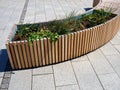 Modern Scandinavian style urban outdoor wooden bench combined with flower planter