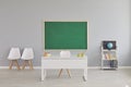 Modern school classroom interior with teacher's desk and chalkboard, space for design. Empty schoolroom with furniture Royalty Free Stock Photo