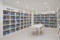 Modern school library interior with white shelves and colorful books in organized rows. concept of educational space, learning Royalty Free Stock Photo