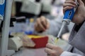 Modern scientist working in biotechnological laboratory equipment for research with pipettes and blue and yellow colorful test tu