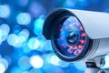 Modern Security Camera with LED Illumination on a Blurry Blue Background, CCTV Surveillance System Royalty Free Stock Photo