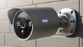 A modern security camera mounted on a brick wall. The camera Royalty Free Stock Photo
