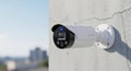 Modern Security Camera Mounted on Textured Wall with Cityscape Background Royalty Free Stock Photo