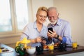 Senior couple shopping online with phone and credit card Royalty Free Stock Photo