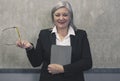 Modern  senior woman in elegant wear holding digital tablet isolated on grey. Portrait of mature female office employee using Royalty Free Stock Photo