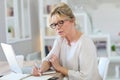 Modern senior woman working on laptop