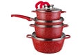 A modern set of dishes from three red pots and one frying pan, stands stacked one on top of the other, on a white background Royalty Free Stock Photo