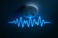 Smoke detector emits sound wave in blue light against dark wall background Royalty Free Stock Photo