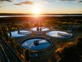 Modern sewage treatment plant. Round wastewater purification tanks at sunset, aerial view