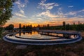 Modern sewage treatment plant. Wastewater purification tanks at sunset