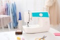Modern sewing machine and accessories on table in dressmaking workshop Royalty Free Stock Photo